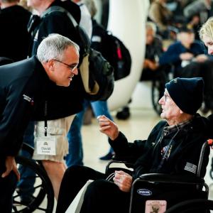 A person talking to a veteran in a wheelchair