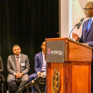 Person talking on stage behind Entergy podium