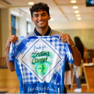 A person holding up a t-shirt 