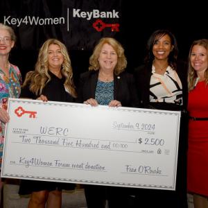 Five people smiling and holding an oversized check from KeyBank