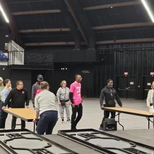 People carrying tables in an auditorium