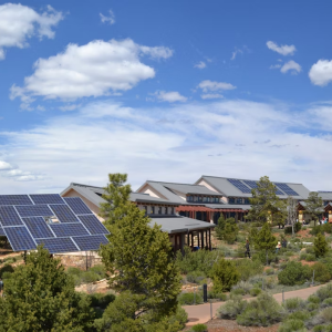 Buildings with solar panels, with a cloudy blue sky above