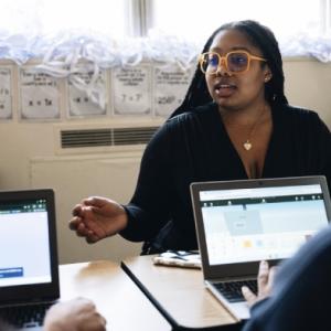 A person sat opposite people working on laptops