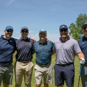 Five people in blue standing together outside