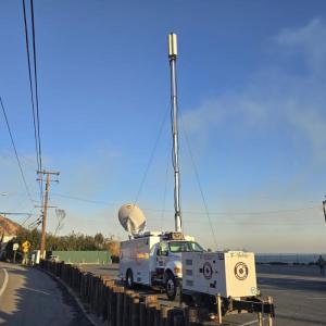 A T-Mobile vehicle on a highway next to a telephone pole and wires