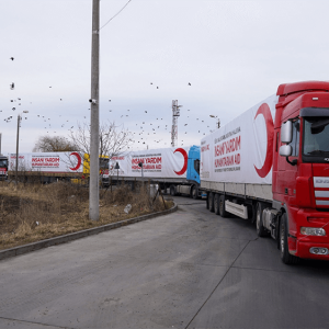 convoy of semi trucks all with red crescent logo on the side