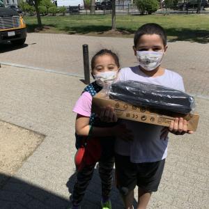 Kids holding computer box and supplies