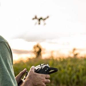 Person flying a drone over a field