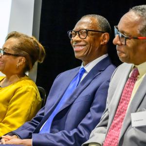 Three people sitting together and smiling