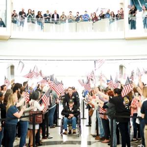 A large group of people waving American flags 
