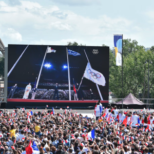 A giant screen being watched by a large crowd