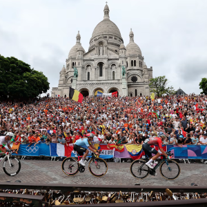 Olympic cyclists with a large crowd behind them