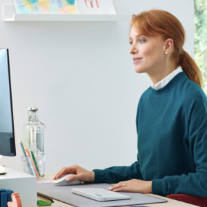 A person sat at a computer desk looking at a monitor screen