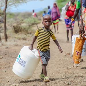 A child in Kenya carries a jerry bucket for safe water storage.