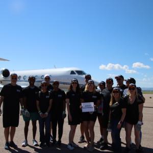 group photo of Arrow employees with the plane in the background