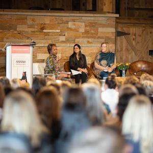 three panelists sit on stage