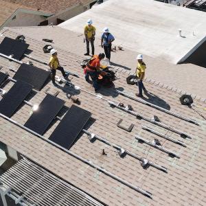Birdseye view of Edison volunteers installing solar panels on a roof
