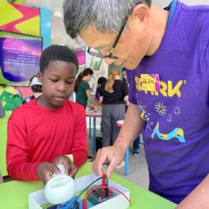 A MilliporeSigma employee teaches a student about the lifecycle of a t-shirt though an interactive experiment.