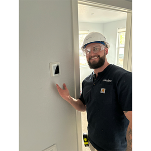 A person showing a thermostat on a wall