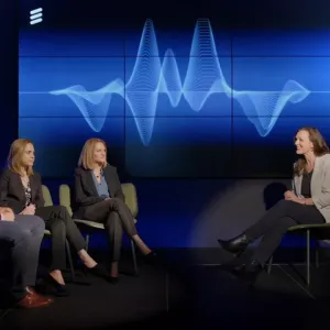 three people sat on chairs being interviewed by a person sat opposite 