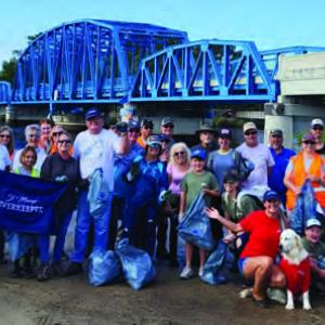 People standing together in front of a bridge
