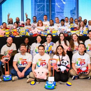 A large group of volunteers holding modified toys 