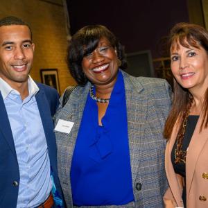 Three people standing together and smiling