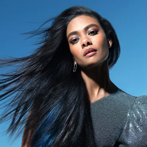 A person with dark hair blowing in the wind