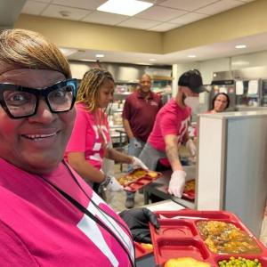 Person smiling with a tray of food