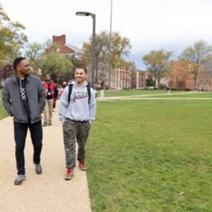 Two people walking on a campus