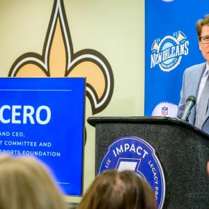 A person in a suit talking behind a podium