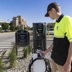 person with electric car charging station