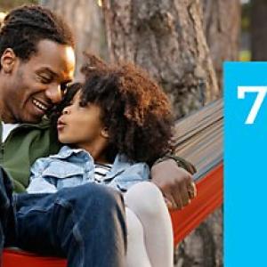 An adult and child in a hammock. "77%" to the side.