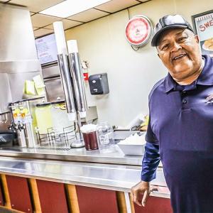 David Swett, cashier, at a counter