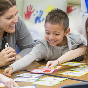 3 children doing a project with a teacher