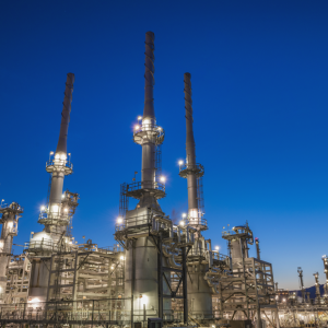 oil refinery illuminated by floodlights at dawn