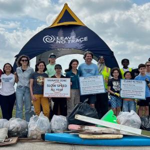 People stood in front of a leave no trace gazebo with bags of rubbish they have collected 