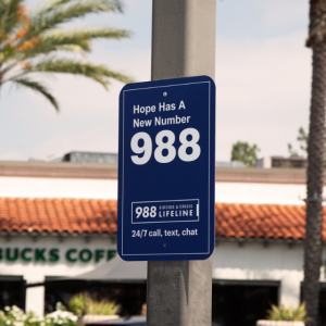 blue 988 sign with palm trees in the background