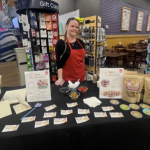 A person standing behind a table with food items