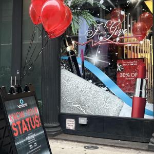 MAC store front with a "Know your status" board with red balloons in front.
