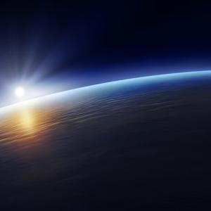 Earth viewed from space, with sun shining behind it