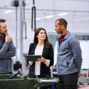 Marine and two others in a manufacturing setting.