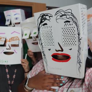 People with decorated, white boxes over their heads.