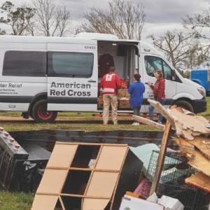 an american red cross van , a pile of debris in front