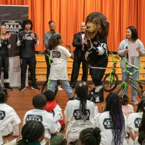 LA Kings mascot Bailey high-fives a student.
