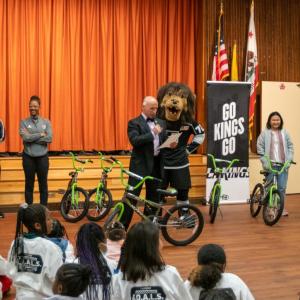 LA Kings Alumni Daryl Evans, Blake Bolden and mascot Bailey greets students at the assembly.