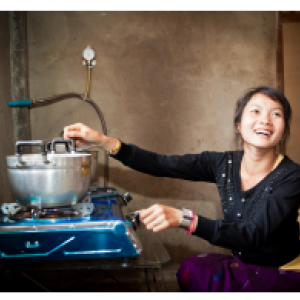 A person using a small cooktop with pot on it.