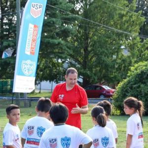 Coach speaking to kids at a soccer field