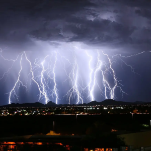 Lightning storm at night over a city.