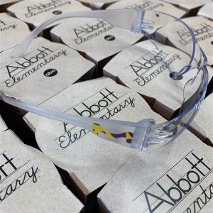 Scientist glasses with MilliporeSigma logo rests on top of small planters that say, "Abbott Elementary"